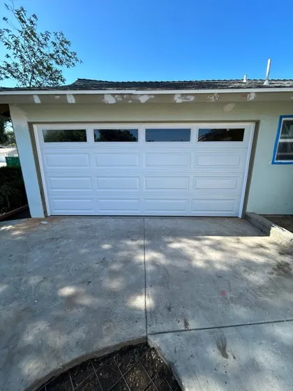 White raised-panel garage door with window row installed in Orange County