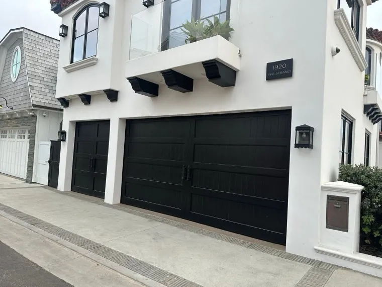 New modern black-frame glass garage door installed on a luxury Orange County home
