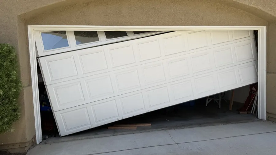 Garage door collapsed diagonally across a driveway after coming off its track — off-track repair in Orange County, CA