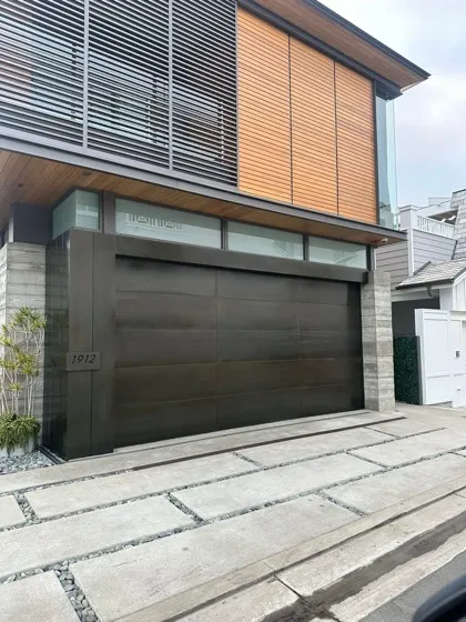Quiet modern wood-slat garage door after roller replacement — roller and track repair in Orange County
