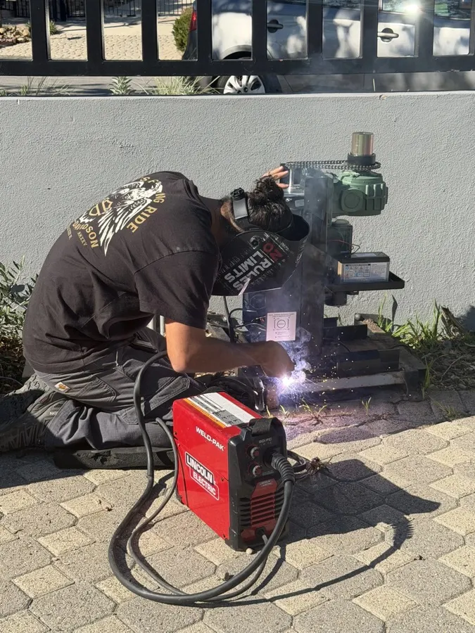 Welder fabricating a steel gate frame with sparks flying — gate motor replacement sized to your gate in Orange County