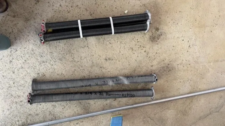 Worn, rusted garage door springs removed after replacement — high-cycle spring upgrade in Orange County, CA