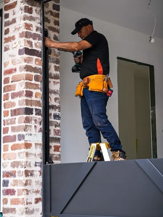 Technician mounting an access control device at a gate column — gate keypad replacement in Orange County, CA