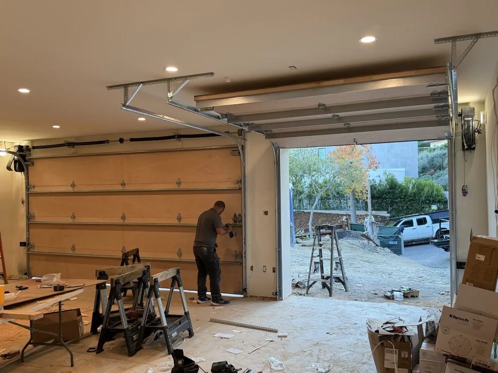 Installer working on a full garage door renovation with new panels — repair and installation team in Laguna Hills, CA